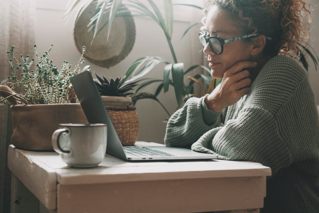 Woman work with notebook at home smiling at the display