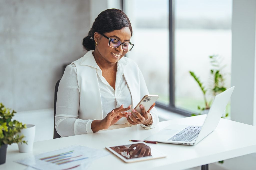 Business girl with phone typing during work break replying to email, sms message or networking via social media app. Communication, text conversation and black woman using smartphone for web search