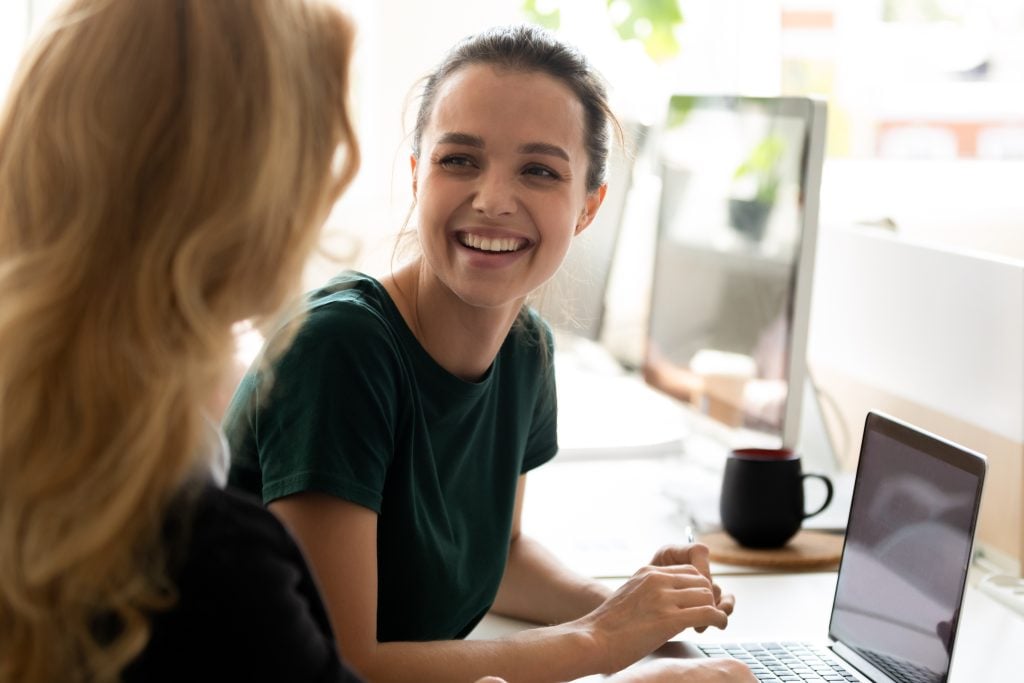 Happy millennial intern, student girl talking to teacher, consulting tutor,