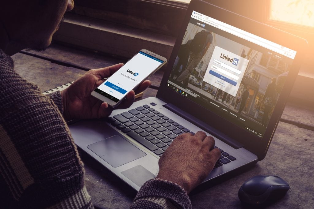 person using linkedin on computer and phone