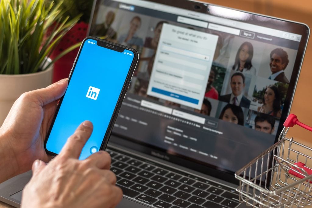 person using linkedin on computer and phone