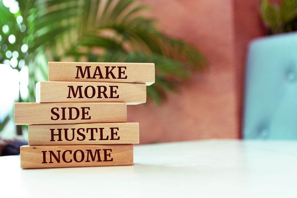 Wooden blocks with words 'Make more side hustle income'.