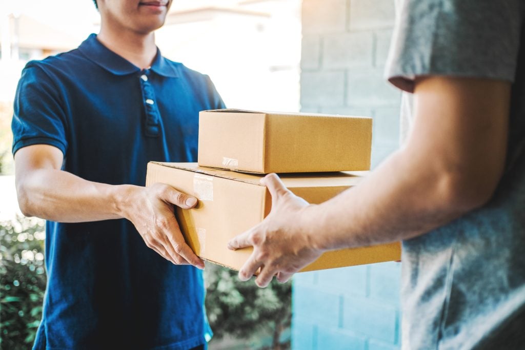 Man hand accepting a delivery boxes from professional deliveryman.