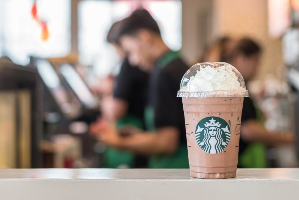 Starbucks coffee cold beverage on table, famous coffee brand franchise originated in USA